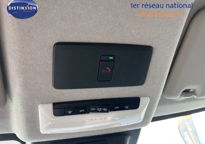 Vue intérieure du plafond avec bouton SOS et commandes d’éclairage dans un Nissan Juke Hybrid gris Squale Metal 2024.