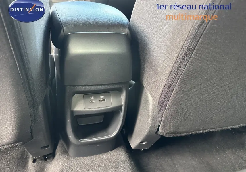 Vue rapprochée de la console arrière entre les sièges noirs en tissu du Nissan Juke gris Squale Metal 2024.