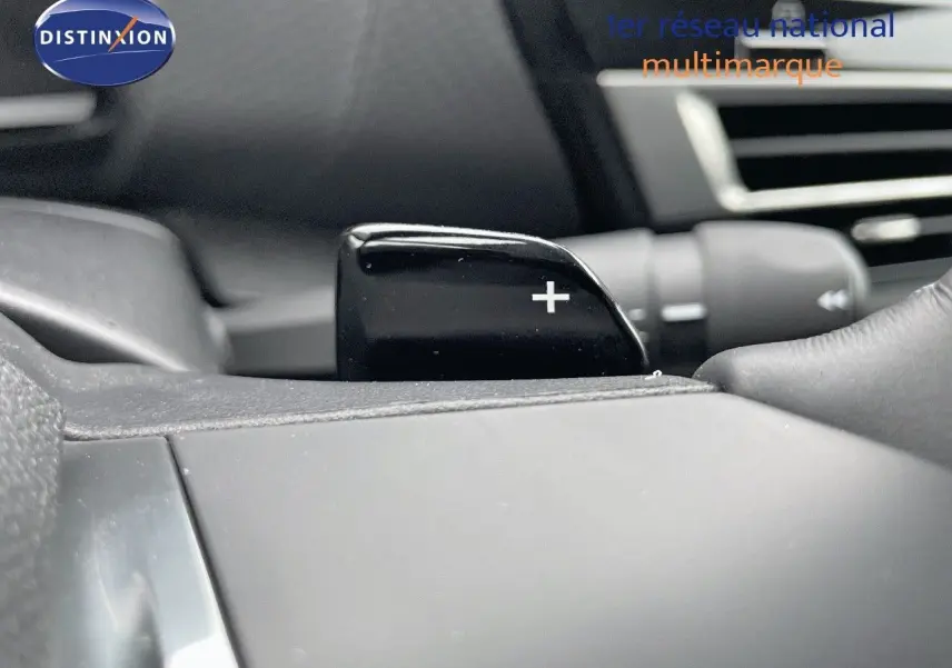 Gros plan sur la palette de passage de vitesses "+" côté droit du volant d'une Citroën C4 blanche métal 2024.