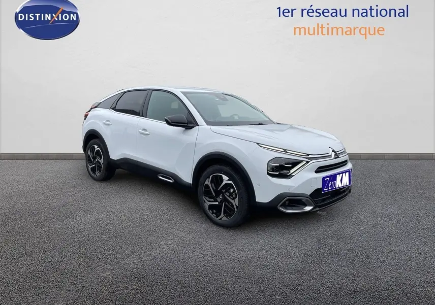 Citroën C4 blanc métal vue 3/4 avant droit, avec jantes noires et détails noirs contrastants.