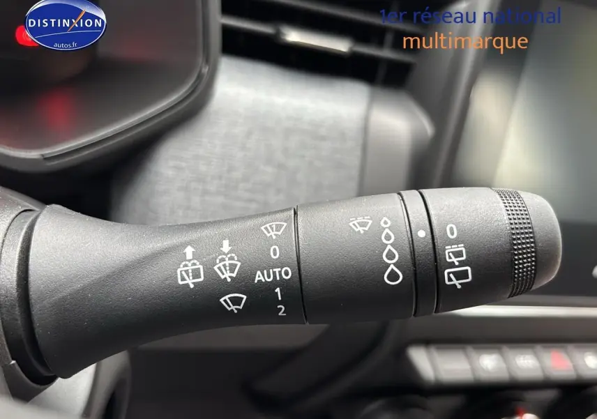 Gros plan sur la commande d'essuie-glace noire dans l'habitacle d'une Renault Clio V noire de 2025.