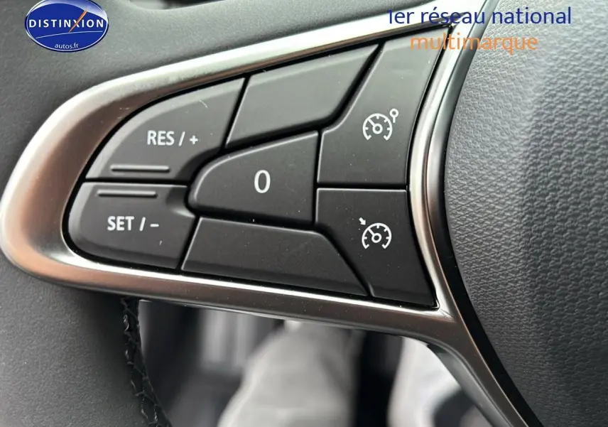 Gros plan sur les commandes du régulateur de vitesse au volant d'une Renault Clio V noire, version 1.5 blue dci 100 evolution.