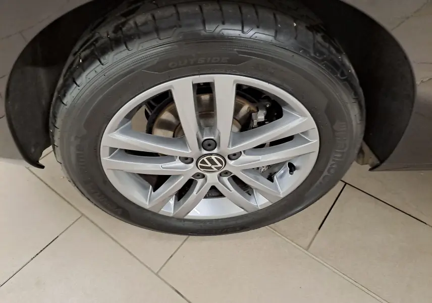 Gros plan sur la roue avant droite du Volkswagen Touran 2025 noir grenadille avec jante alliage argentée.