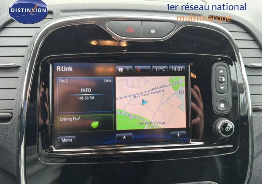Écran tactile central du Renault Captur 2016, affichant GPS et radio, entouré de commandes noires brillantes.