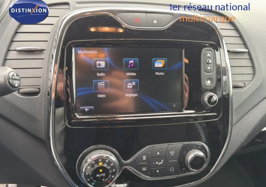 Vue rapprochée de la console centrale noire brillante du Renault Captur 2016 avec écran tactile multimédia allumé.