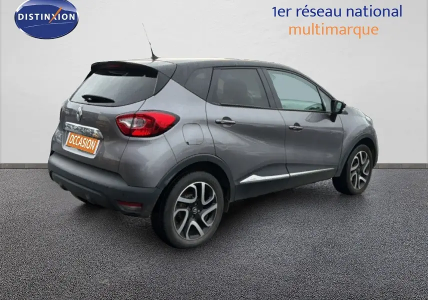 Vue 3/4 arrière droite d'un Renault Captur gris Cassiopée avec toit noir et jantes alliage bicolores.
