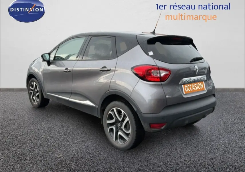 Renault Captur gris Cassiopée avec toit noir, vue 3/4 arrière droit, jantes alliage et feux arrière visibles.