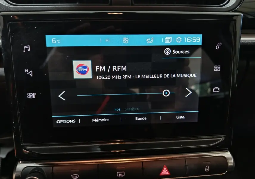 Écran tactile central de la Citroën C3 gris foncé 2024 affichant la radio FM sur fond noir brillant.