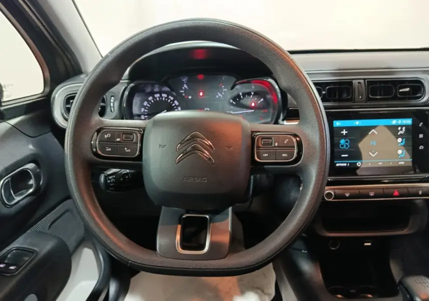 Vue intérieure centrée sur le volant multifonctions noir et l’écran tactile du tableau de bord d’une Citroën C3 2024.