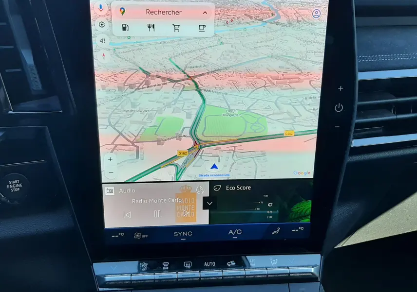 Écran tactile central du tableau de bord du Renault Austral 2025, affichant la navigation GPS et les commandes climatisation.