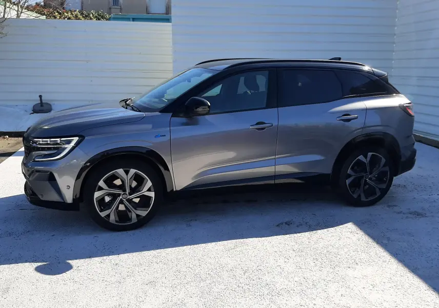 Renault Austral E-Tech hybride gris schiste avec toit noir, vue de profil côté gauche, jantes alliage distinctives.