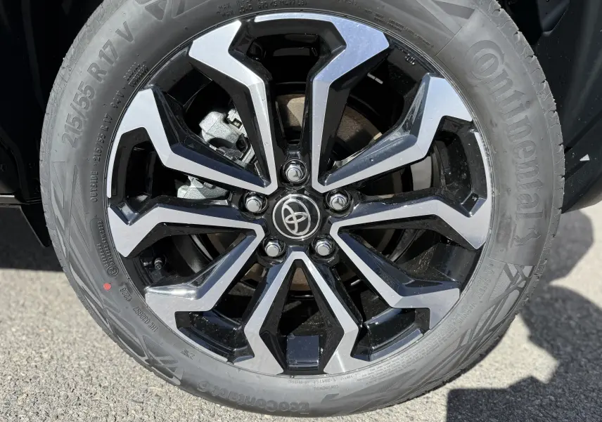 Gros plan sur la jante alliage bicolore noire et argentée du Toyota Yaris Cross gris atlas metal, pneu Continental visible.