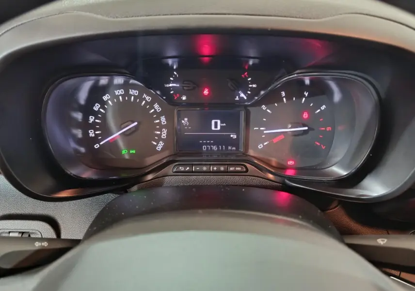 Vue rapprochée du tableau de bord noir du Citroën Berlingo 2021, affichant compteur et témoins lumineux allumés.