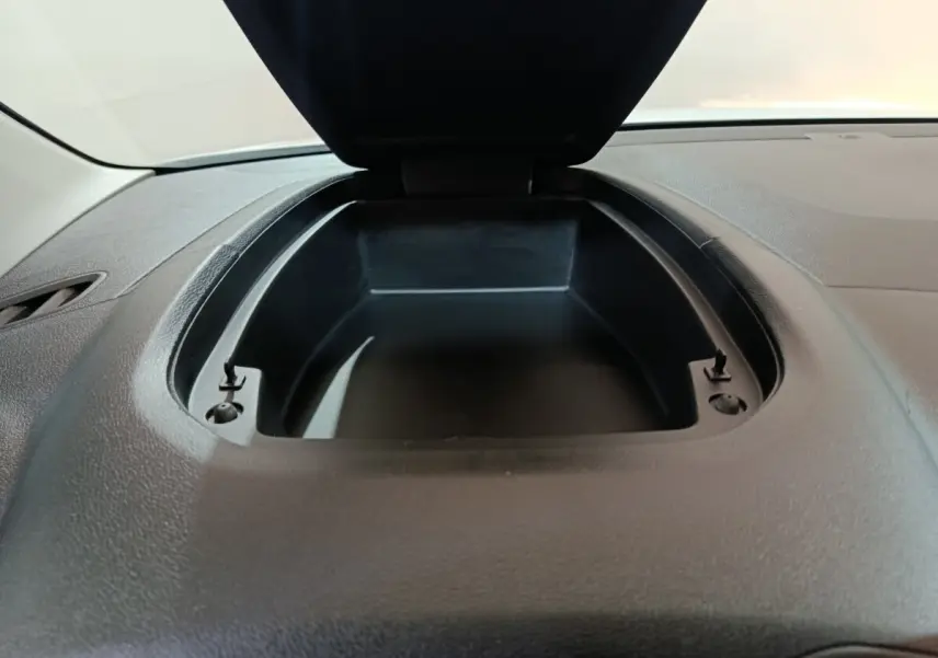 Vue rapprochée de la boîte de rangement ouverte sur le tableau de bord noir du Citroën Berlingo blanc 2021.