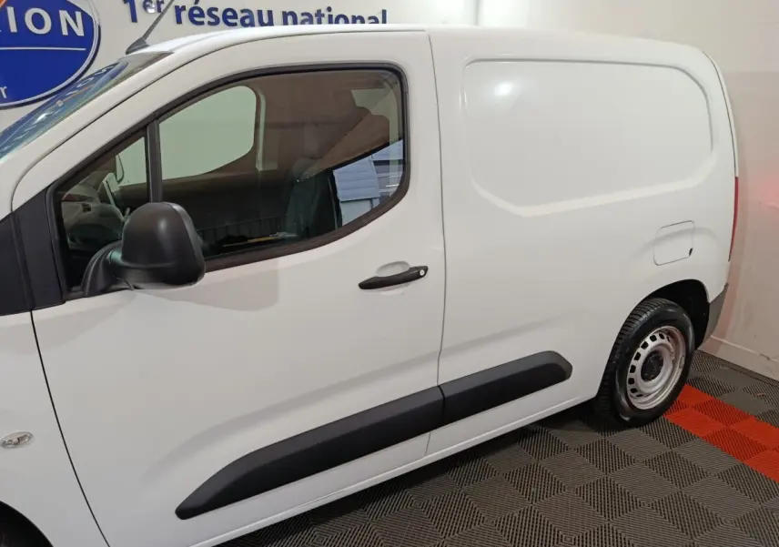 Vue latérale gauche d’un utilitaire Citroën Berlingo blanc avec porte latérale pleine et jante acier.