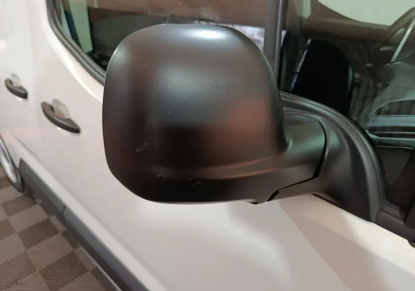 Gros plan sur le rétroviseur noir côté conducteur du Citroën Berlingo blanc, vue latérale gauche.