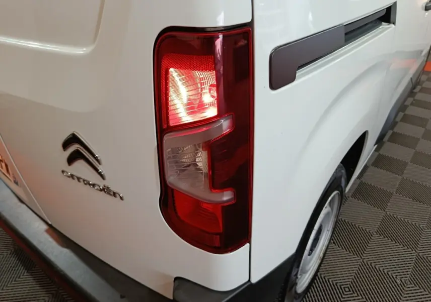 Feu arrière droit allumé sur Citroën Berlingo blanc, vue rapprochée du côté arrière droit du véhicule.