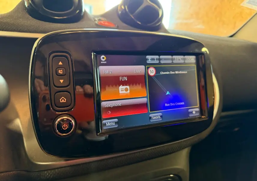 Vue rapprochée de l’écran tactile GPS du tableau de bord de la Smart Fortwo Cabrio noir, affichant la navigation.