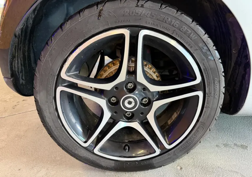 Gros plan sur la jante alu 16 pouces noire et argentée d’une Smart Fortwo Cabrio 2019, avec pneu visible.