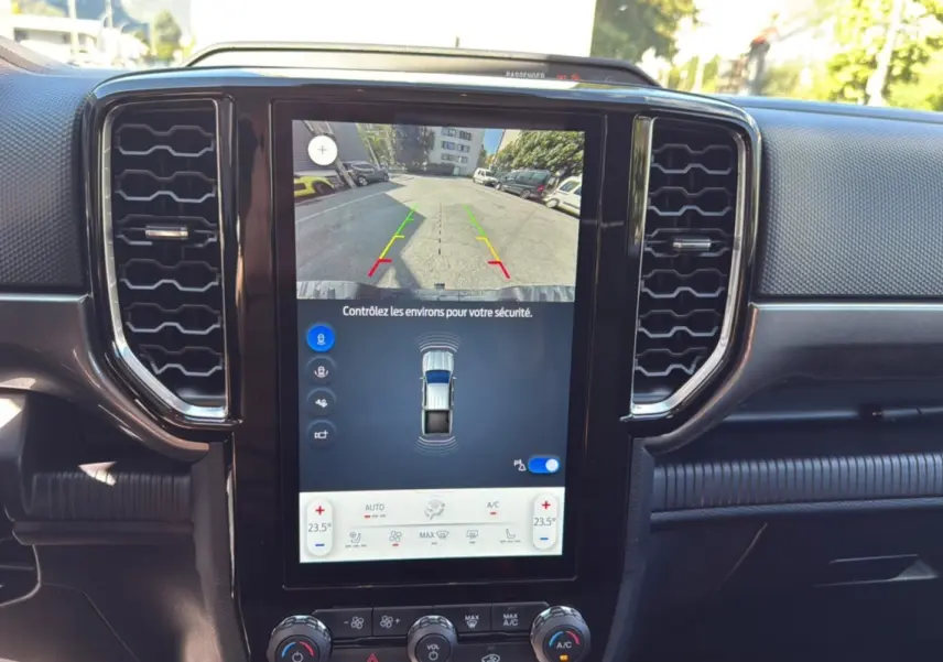 Vue rapprochée de l’écran central tactile du Ford Ranger blanc glacier, affichant la caméra de recul et la climatisation automatique.