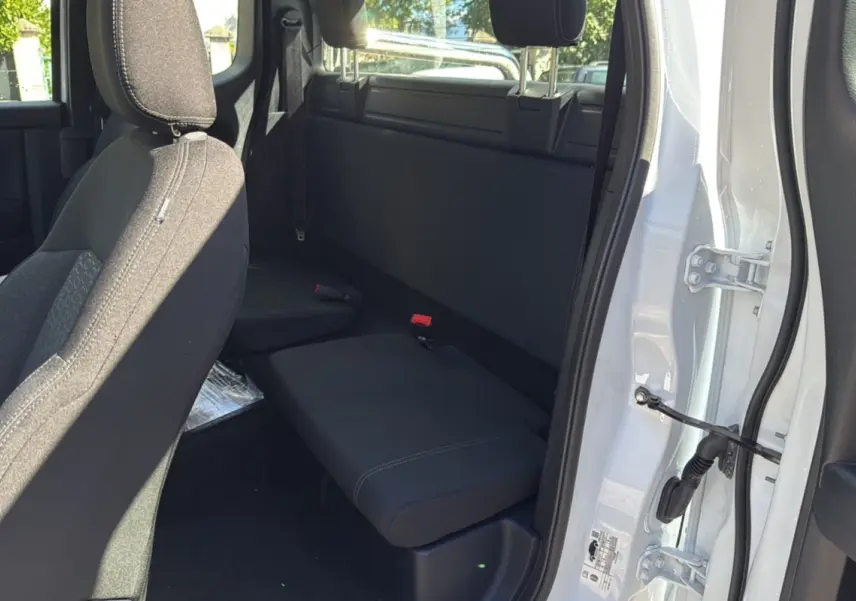 Vue intérieure côté arrière droit du Ford Ranger blanc glacier, montrant la banquette arrière et la porte ouverte.