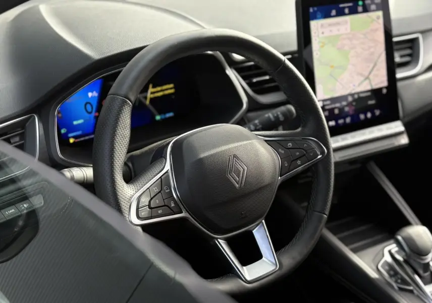 Vue intérieure centrée sur le volant noir du Renault Symbioz 2025 avec écran tactile vertical et tableau de bord numérique.