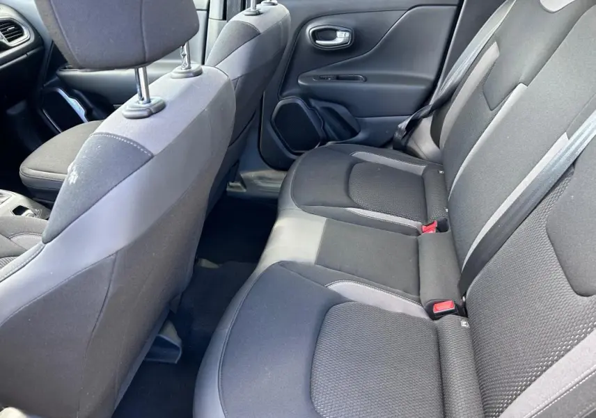 Vue intérieure côté droit des sièges arrière noirs du Jeep Renegade 2023, tissu avec ceintures de sécurité visibles.