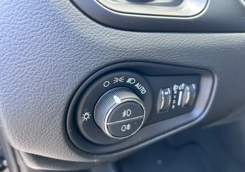 Gros plan sur la molette de réglage des phares et des feux antibrouillard dans l'habitacle du Jeep Renegade 2023.