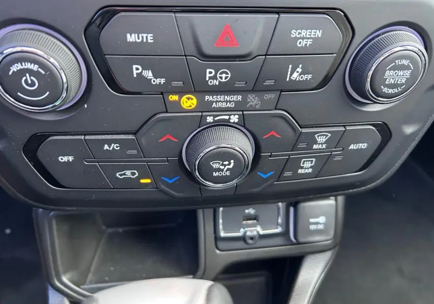 Gros plan sur la console centrale noire du Jeep Renegade 2023, avec commandes climatisation et boutons multifonctions.
