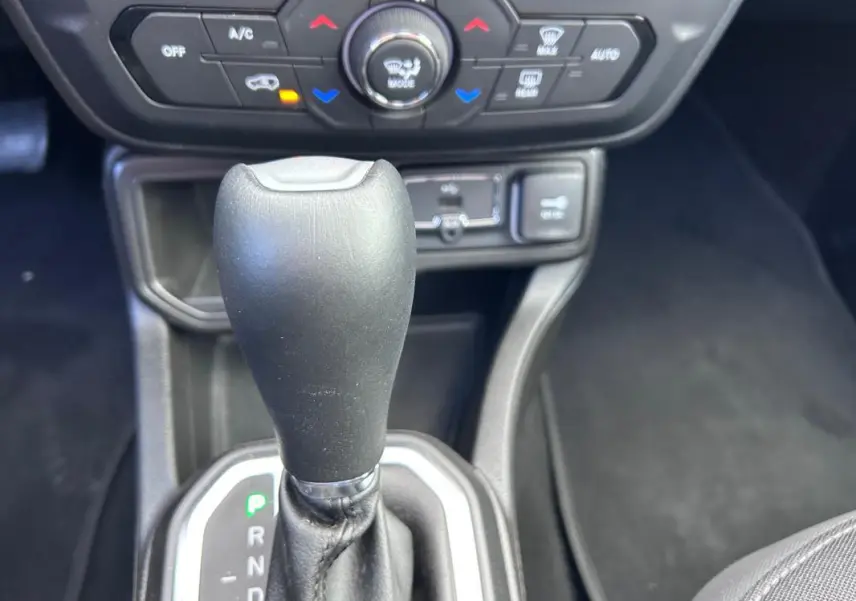 Gros plan sur le levier de vitesse automatique noir de la Jeep Renegade 2023 avec commandes de climatisation en arrière-plan.