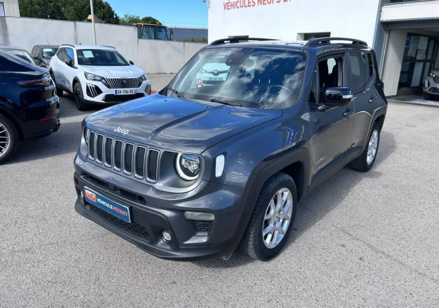 Jeep Renegade bleu foncé en 3/4 avant droit, avec barres de toit et jantes alliage 17 pouces visibles.