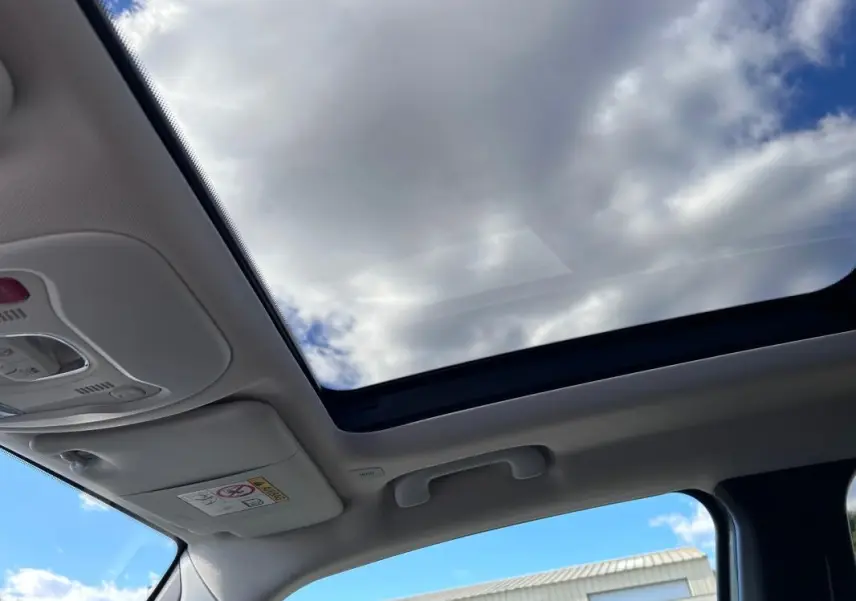 Toit ouvrant panoramique ouvert montrant le ciel, intérieur clair du Jeep Renegade 2023.