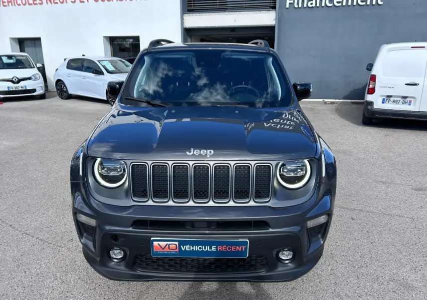 Vue de face d’un Jeep Renegade bleu foncé 2023 avec phares LED circulaires allumés et calandre distinctive.