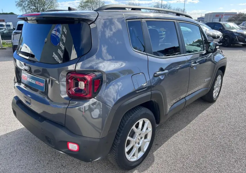 Vue 3/4 arrière droite d'un Jeep Renegade bleu foncé avec barres de toit et jantes alliage 17 pouces.