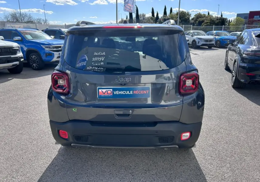 Vue arrière d’un Jeep Renegade bleu foncé 2023 avec feux carrés caractéristiques et barres de toit visibles.