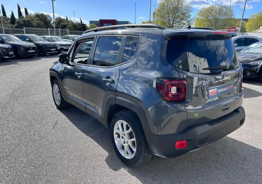 Vue 3/4 arrière droite d'un Jeep Renegade bleu foncé avec barres de toit et jantes alliage 17 pouces.