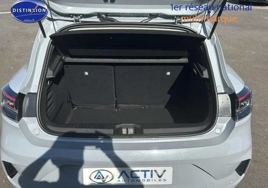 Coffre ouvert vu de l'arrière d'une Renault Clio V gris rafale, montrant l'espace de chargement vide.