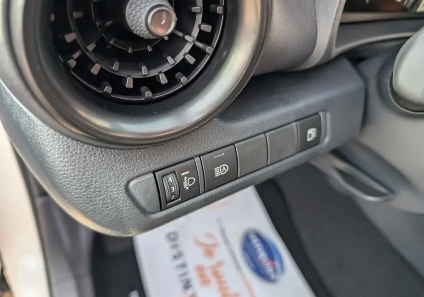 Détail des commandes côté gauche du tableau de bord du Toyota C-HR blanc 2024, avec aérateur rond et réglages lumineux.