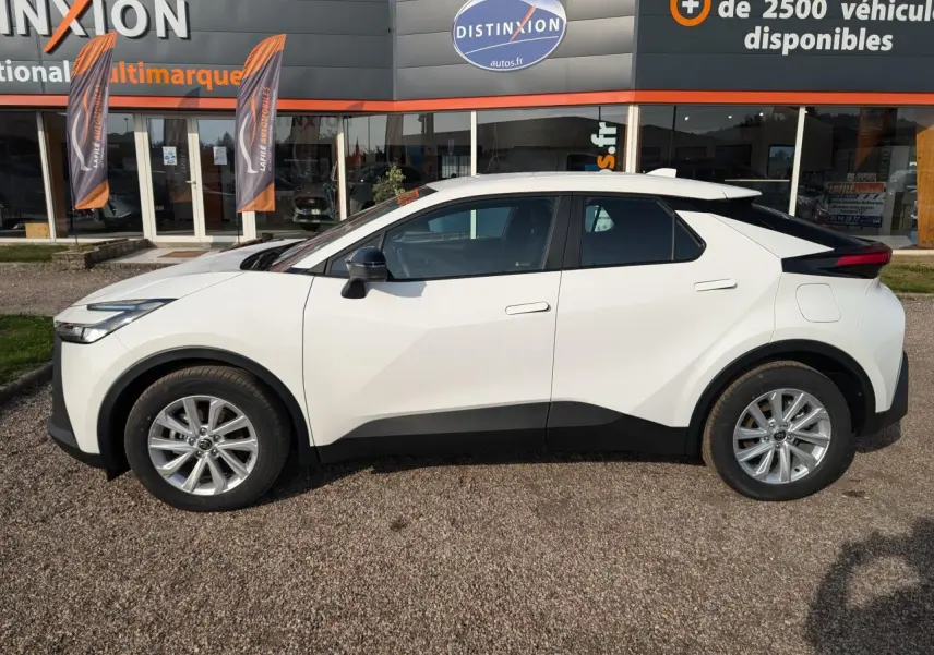 Vue latérale droite du Toyota C-HR 1.8 Hybrid blanc 2024 avec détails noirs contrastants et jantes alliage.