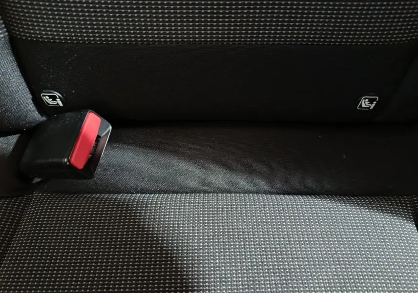 Gros plan sur la banquette arrière grise à motifs avec boucle de ceinture et fixations Isofix visibles.