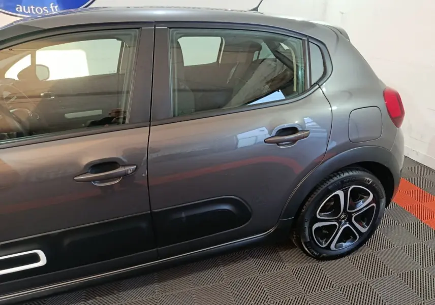 Vue latérale droite d'une Citroën C3 gris foncé avec jantes noires et détails de protection de porte noirs.