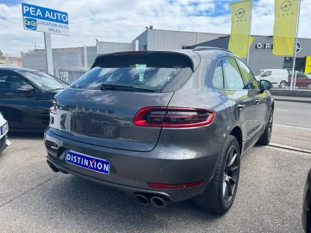 Vue 3/4 arrière d'un Porsche Macan gris 2015 diesel, avec double sortie d'échappement et jantes foncées.