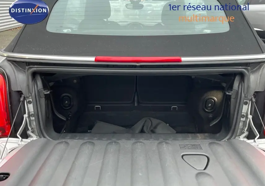 Coffre ouvert vu de l'arrière d'une MINI Cabriolet F57 2023 couleur Melting Silver Metal avec toit noir relevé.