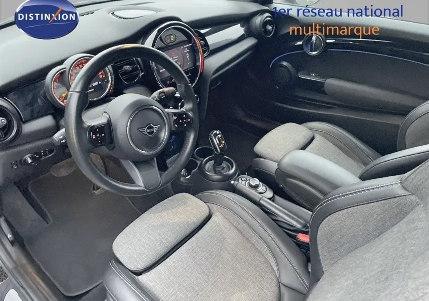 Intérieur de MINI Cabriolet F57 2023 vu côté conducteur, sièges gris clair avec cuir noir et tableau de bord moderne.