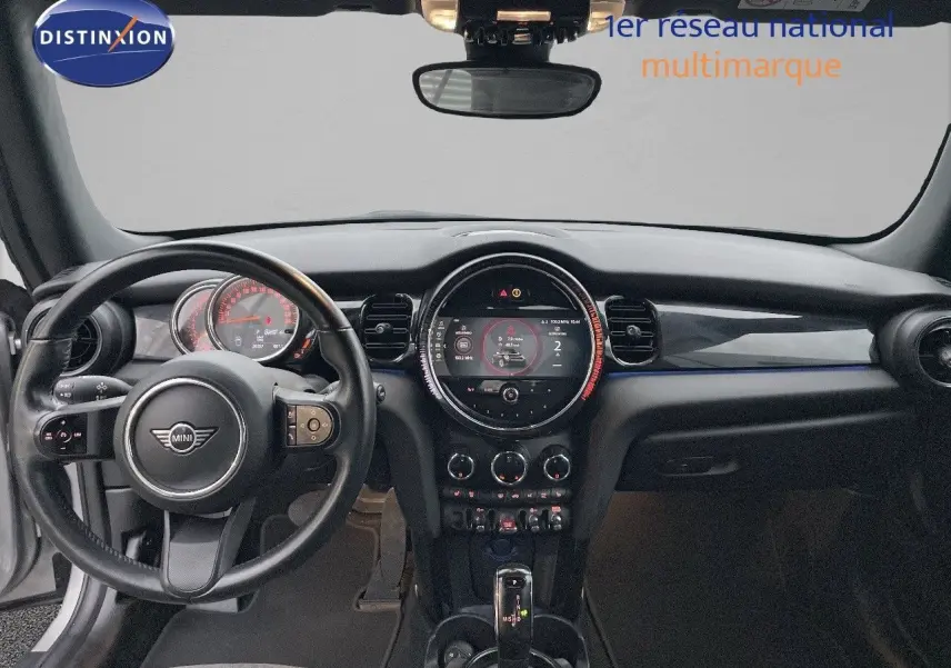 Intérieur noir du MINI Cabriolet F57 2023, vue frontale sur le tableau de bord et volant avec écran central rond.