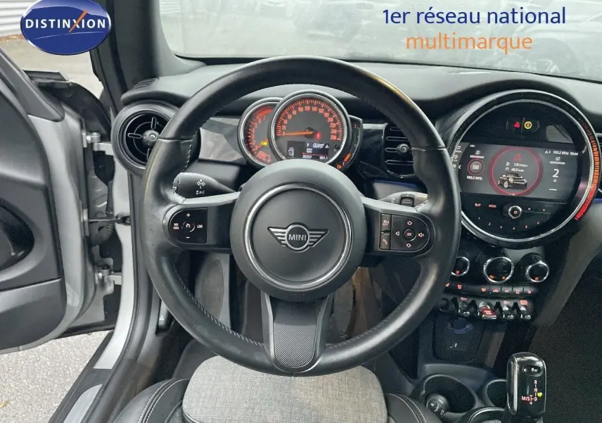 Vue intérieure centrée sur le volant et le tableau de bord d'une MINI Cabriolet Melting Silver 2023, avec boîte auto.