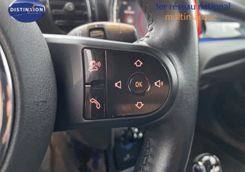 Gros plan sur les commandes au volant en cuir noir du MINI Cabriolet Melting Silver 2023, avec boutons multifonctions éclairés.