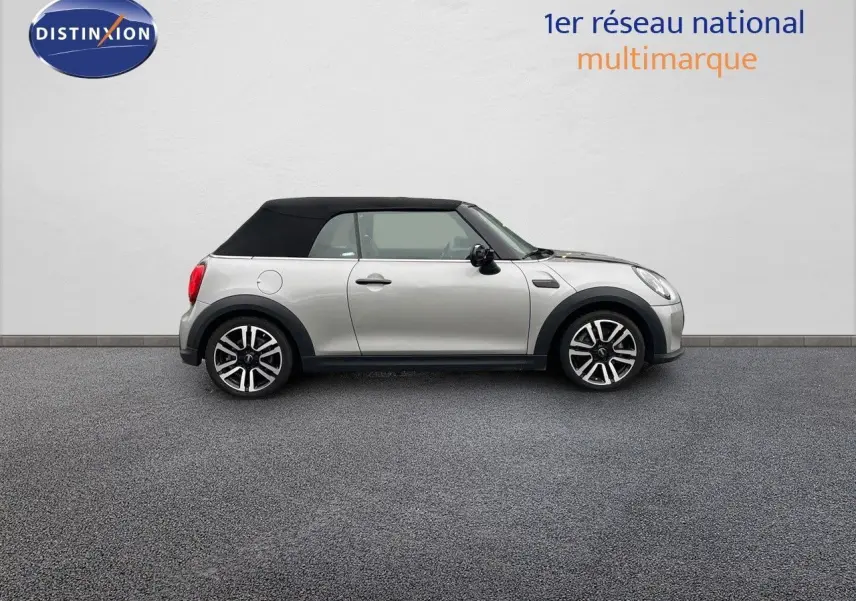 Profil droit d'une MINI Cabriolet 2023 couleur argent métallisé avec toit noir fermé sur fond neutre.