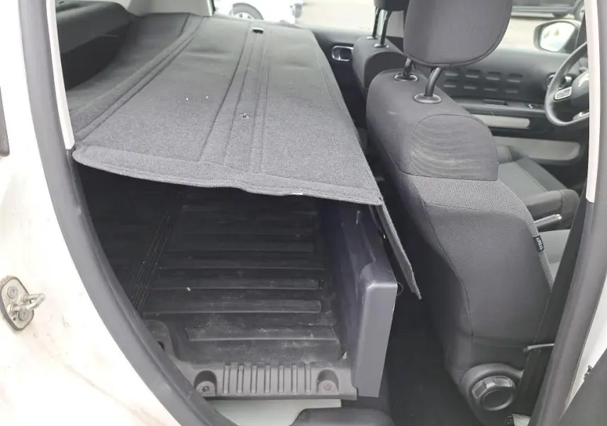 Vue intérieure côté gauche du Citroën C3 Société blanc 2022, montrant la banquette rabattue et le coffre de chargement.