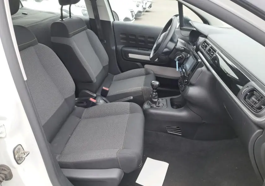 Intérieur de la Citroën C3 Société blanc, vue côté conducteur montrant sièges tissu gris et tableau de bord moderne.